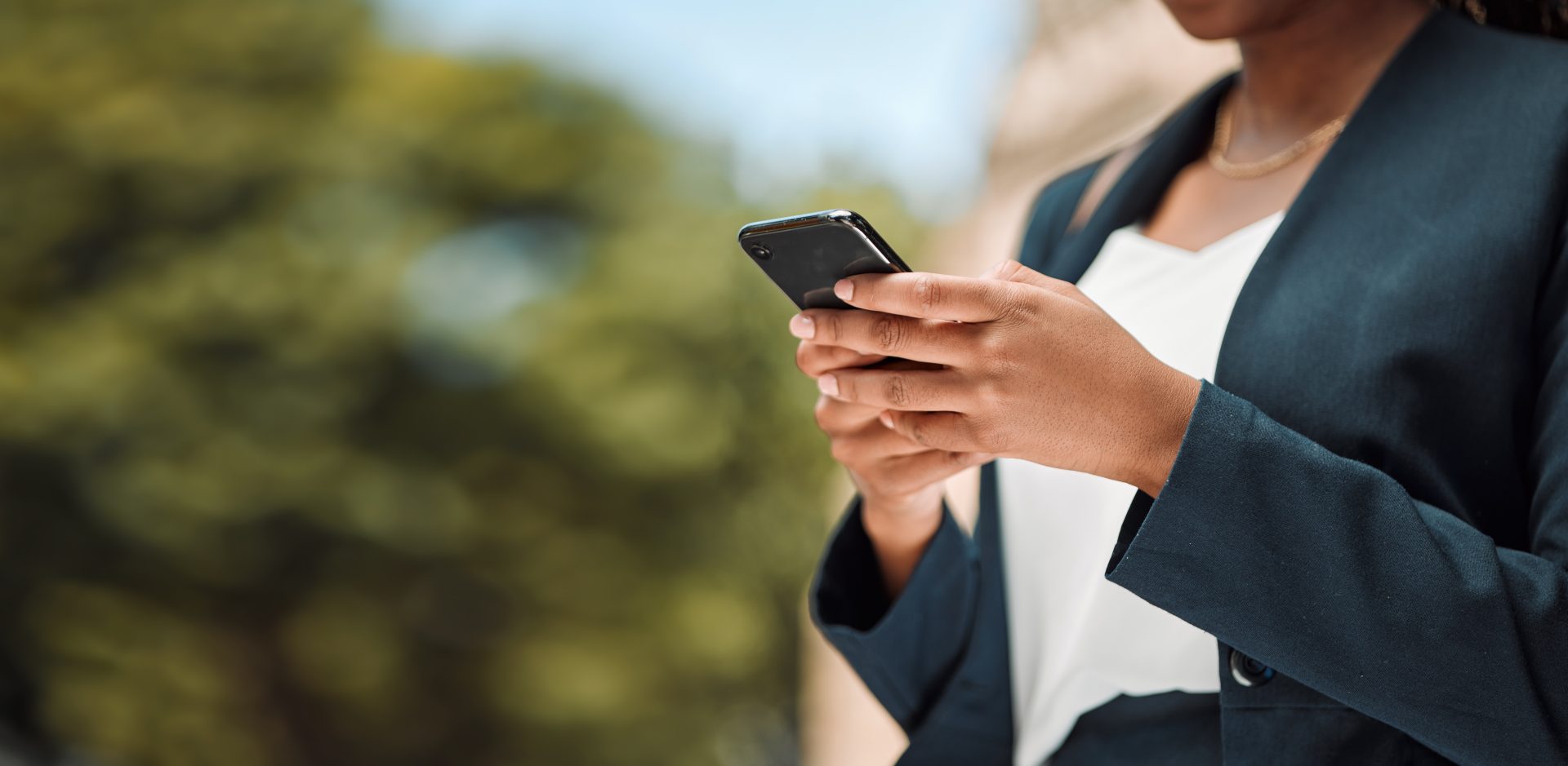 Woman, hands and phone in city for communication, social media or networking outdoors. Closeup of f.