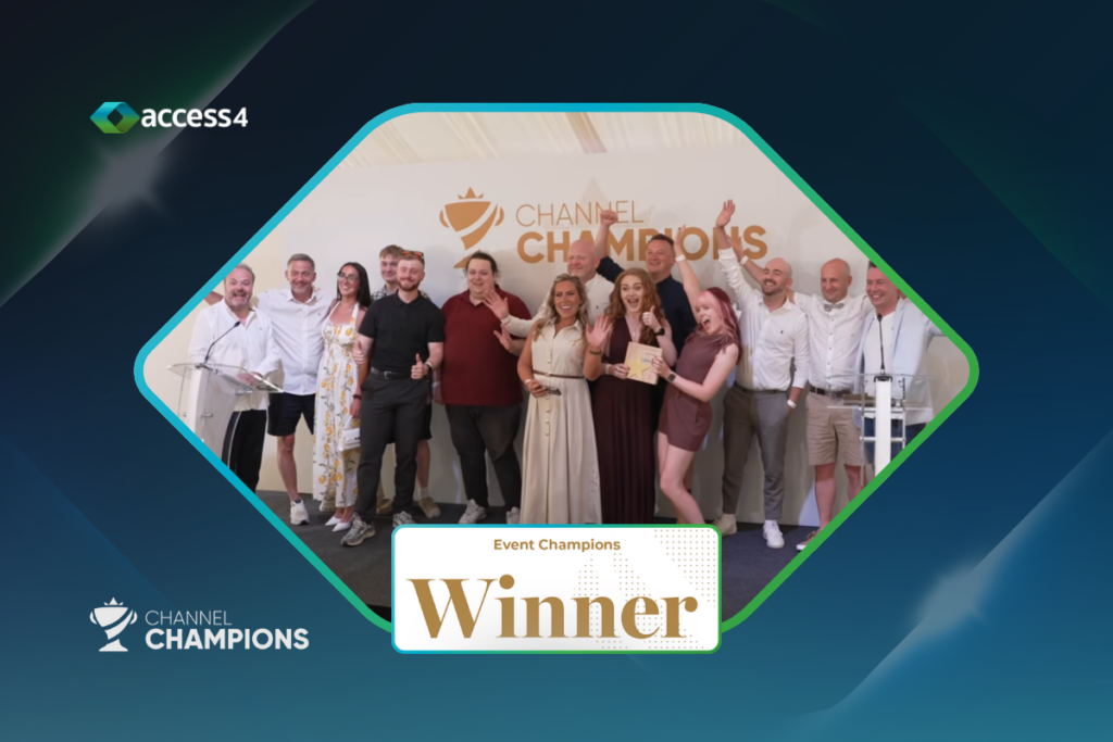 Group of people posing on stage at an awards event, holding a trophy with a centered 'Winner' banner in front; backdrop reads 'Channel Champions'.